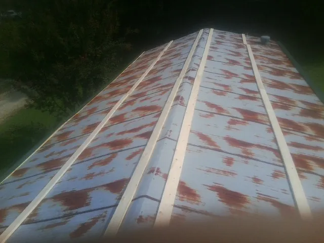 Rusted metal roof panels with new wood purlins before replacement — Storm Damage Roof Repair in Creal Springs by Roofing Brothers